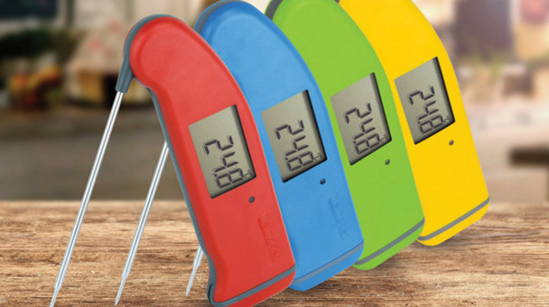 A selection of ETI Thermapens stood on a wooden counter. All show 24.8°C on their digital displays. From front to back and moving left to right the colours are: red, blue, green, and yellow. 