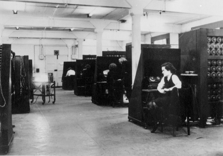 Black and white photo of  WRENS operating Bombe codebreaking machines at RAF Eastcote in 1944.